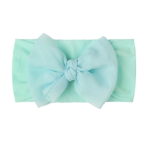 Detail shot of a baby nylon headband with a large soft mint green decorative bow