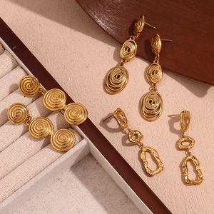 Détail de boucles d'oreilles en acier doré 18 carats avec texture géométrique martelée