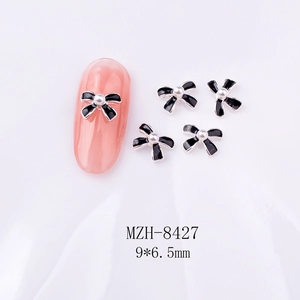 Makro-Detail von 9x6,5mm Emaille-Schleifen-Nagelkunst mit weißer Perle in der Mitte