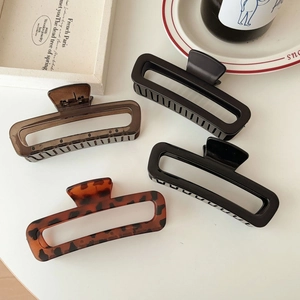 Detailed view of large acetate claw clips in black and tortoiseshell rectangular design