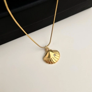 Detail of 18K gold plated seashell pendant with zircon on a sleek snake chain