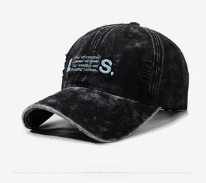 Close-up of distressed washed black baseball cap with blue 3D letter embroidery details
