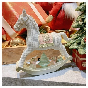 Close-up of resin rocking horse with knitting texture and miniature Christmas gifts