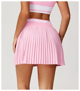 Close-up of pink pleated tennis skirt featuring white striped elastic waistband for sports