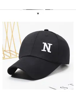 Close-up of black baseball cap featuring detailed white embroidered letter N on cotton fabric