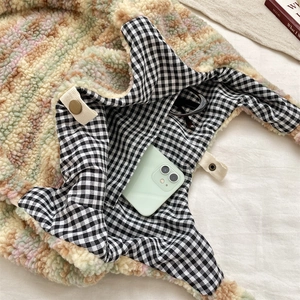 Detail view of plush tote bag interior with checkered lining and pocket for sunglasses