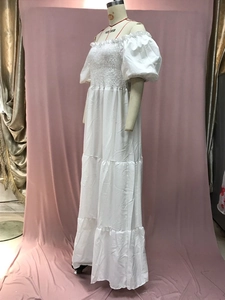 Detail of smocked bodice and puff sleeves on white off-shoulder tiered maxi dress