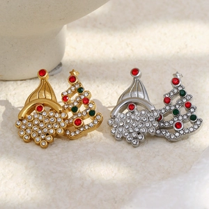 Macro detail of Christmas tree earrings with red and green rhinestones in gold and silver
