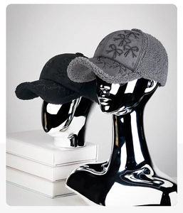 Detailed view of plush winter baseball caps with rhinestone bows in black and gray
