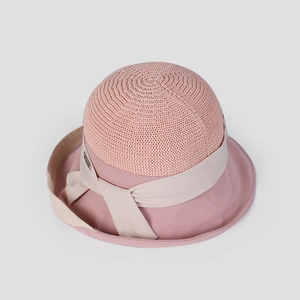 Detail of pink crochet sun hat featuring a wide brim and elegant cream ribbon bow