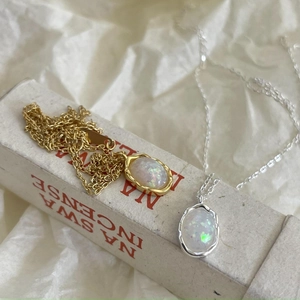 Detailed view of gold and silver opal necklaces showing brilliant fire color effect