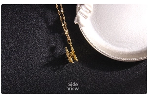 Macro side view of golden clover pendant featuring intricate zircon side inlay details