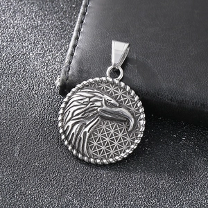 Macro detail of silver Viking pendant featuring an eagle head and Flower of Life pattern