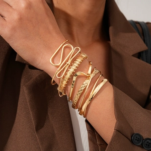 Vue détaillée de six bracelets dorés géométriques avec texture martelée et design ondulé moderne