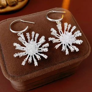 Vue détaillée des boucles d'oreilles flocon en argent et zircons sur écrin de velours