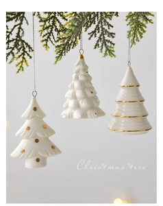 Three minimalist white ceramic Christmas tree ornaments with gold dots and silver cords