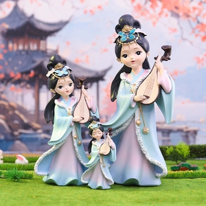 Three Chinese ancient beauty figurines in blue and pink gowns playing pipa on green grass
