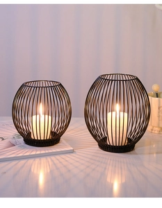 Detail of modern black iron birdcage candle holders with striped shadow effects