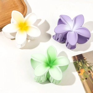 Macro detail of matte floral hair claws in gradient colors with strong spring teeth