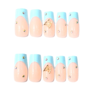 French tip press-on nails in light blue with gold 3D butterflies and sparkling rhinestones