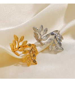 Detailed close-up of gold and silver leaf-shaped open rings on champagne silk