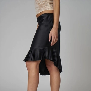 Detail of black satin skirt with pleated hem and asymmetric irregular fishtail cut