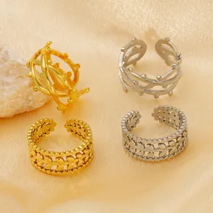 Stack of 18k gold and silver geometric open rings with hollow leaf and bead patterns