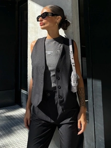 Close-up of black tailored vest with buttons over a Tribeca 1996 graphic top set