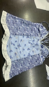 Detailansicht eines Camisole-Tops mit Blumendruck, Spitzensaum und weißem Rüschenrand