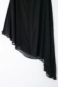 Vue détaillée d'une robe en mousseline noire avec ourlet asymétrique et texture de tissu voile
