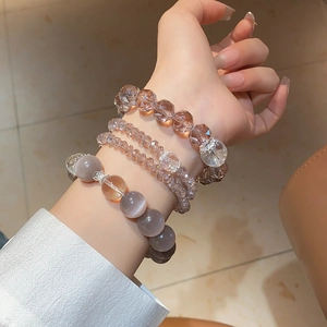 Detail of layered beaded bracelet with cat eye stones and champagne faceted crystals