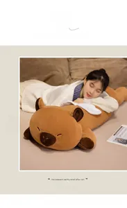 Soft capybara plush pillow with angel wings shown in a cozy home environment