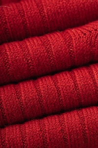 Gros plan de chaussettes épaisses en laine rouge montrant la texture du tricot