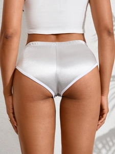 Dettaglio dei pantaloncini di raso argento con elastico bianco e bordo rifinito