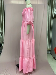 Detail showing the pink smocked bust and tiered skirt of an off-shoulder dress