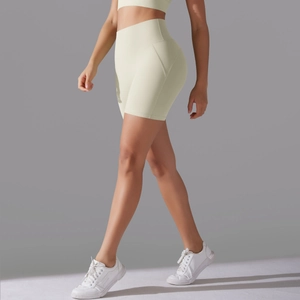 Detail view of high-waisted beige gym shorts featuring curved side stitching and sleek fit