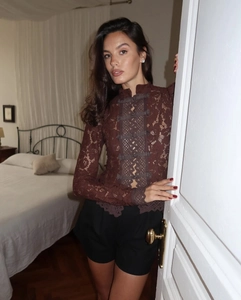 Detalle de la blusa de encaje marrón oscuro con ganchillo floral y botones chinos