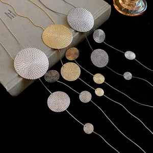 Metallic geometric long fringe necklace with spiral texture circles on a dark background