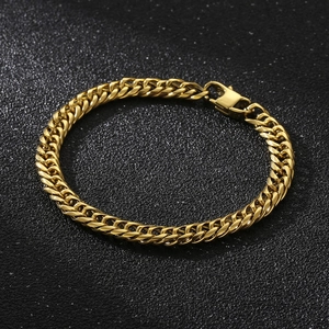 Détail d'un bracelet gourmette épais plaqué or 18K avec fermoir mousqueton sur fond noir