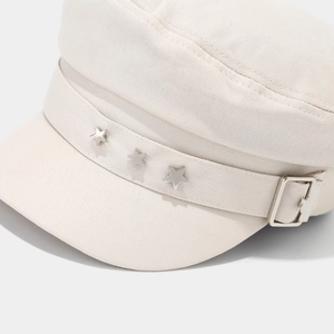 Détail de la casquette gavroche beige avec clous étoiles et texture en coton sergé