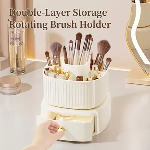 Rotating makeup brush organizer with creamy white tiered design and golden handle drawer