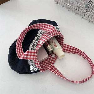Détail du mini sac en denim avec bordure en dentelle blanche et anses à carreaux rouges
