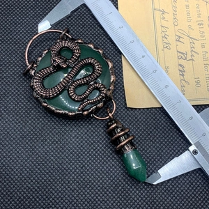 Detail view of retro bronze snake pendant with green aventurine crystal measuring 8cm