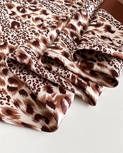 Close-up of leopard print satin silk scarf showing smooth texture and fabric folds