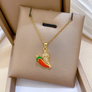Close-up of a gold chili pendant necklace with red enamel and sparkling crystal stones