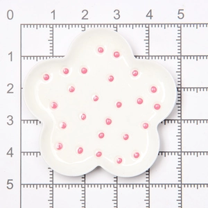 Macro shot of a 4.5cm miniature flower plate with pink polka dots for dollhouse DIY decoration