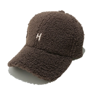 Gros plan de la casquette de baseball en laine bouclée marron avec lettre H brodée en 3D