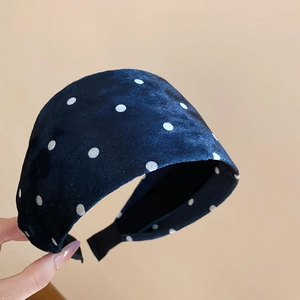 Detail of wide navy blue headband with white polka dots and soft velvet texture