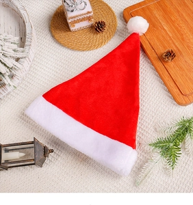 Classic red Christmas hat with white plush trim and pompom on festive rustic background