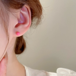 Close-up of pink round bead stud earrings worn by a model for a sweet minimalist look